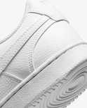 Close-up van de zijkant en zool van een witte Nike sneaker met getextureerd leer.