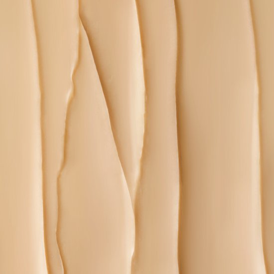 Een abstracte, golvende textuur van bleke, crème-achtige substantie.