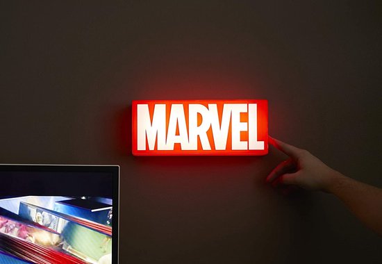 Vinger raakt een verlichte rode MARVEL-logo lamp met witte letters aan de muur aan.