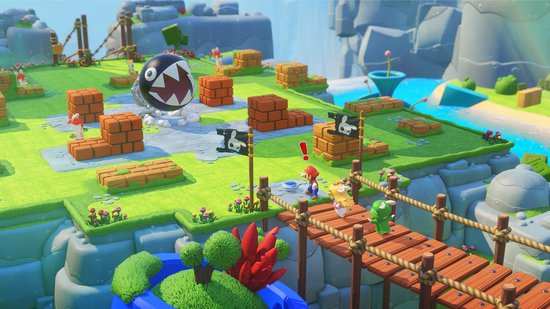Gameplay van Mario + Rabbids Kingdom Battle met Mario, Peach en Rabbid Yoshi op een houten brug die een ravijn overspant, met een Chain Chomp in de achtergrond.