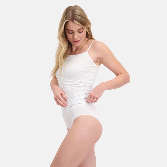 Zijaanzicht van model in witte Bamboo Basics set met hemdje en slip, voorzien van het Bamboo Basics logo.