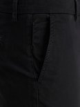 Detail van de zak van een zwarte chinobroek.