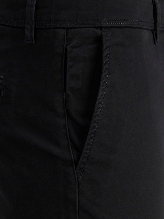 Detail van de zak van een zwarte chinobroek.