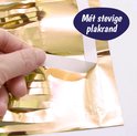 Hand trekt de plakrand van een gouden glittergordijn los.