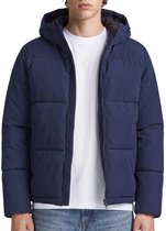 Model draagt een donkerblauwe pufferjack met rits en witte T-shirt.