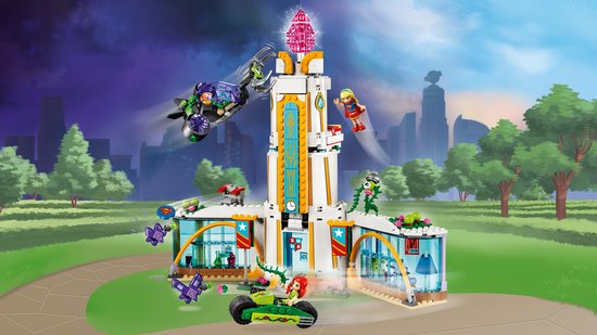 LEGO Superheldenschool in actie met gebouw, voertuigen, minifiguren en een stad op de achtergrond.