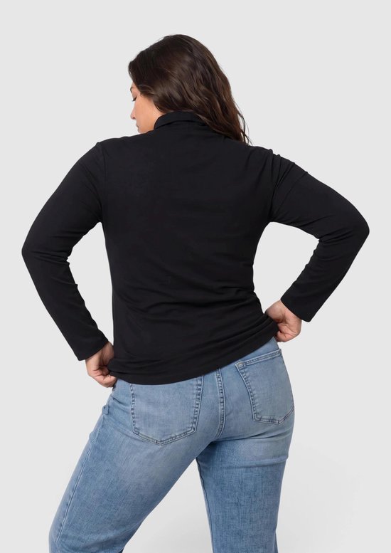 Achteraanzicht van een vrouw in een zwarte coltrui met lange mouwen en een blauwe jeans.