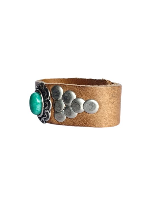 Bruin leren armband met een turquoise steen en zilverkleurige studs in een cluster aan de zijkant.