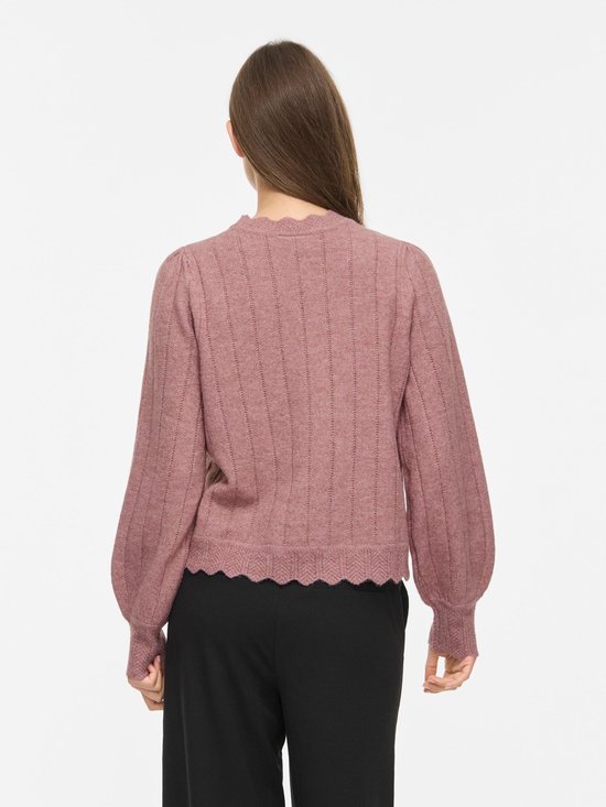 Model van achteren gezien met roze VILA gebreide trui en zwarte broek.