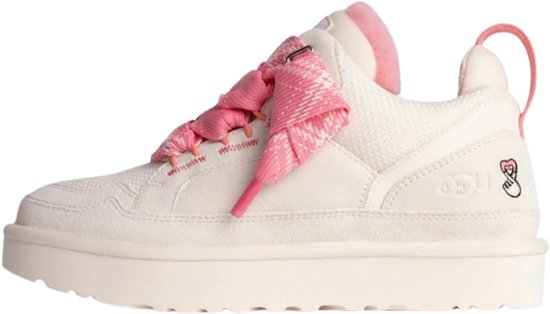 Crèmewitte UGG sneaker met roze veters, roze tong, dikke zool en een geborduurd hart-vingergebaar op de hiel.