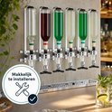 Zes flessen drank met gekleurde banden, elk met een chroomkleurige dispenser, gemonteerd op een muurbevestiging.