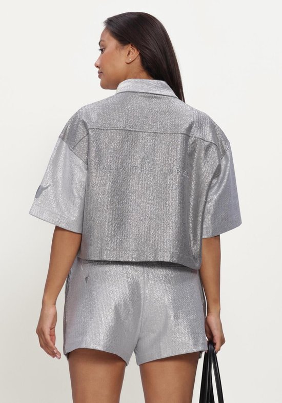 Achterkant van zilverkleurige, glanzende cropped blouse met korte mouwen, met 'ALIX THE LABEL' op de rug.