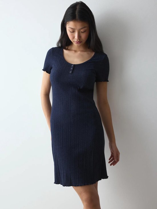 Model draagt donkerblauw, nauwsluitend nachthemd met korte mouwen, ronde hals en geribde stof.