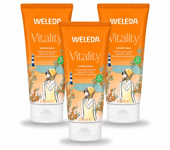 Drie oranje tubes Weleda Vitality douchecrème met duindoorn. De tubes tonen een illustratie van een strand met zee, een vuurtoren en een vrouw met gele sjaal.