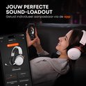 Vrouw met een witte Beyerdynamic MMX 150 headset op, kijkend naar een smartphone waarop de Beyerdynamic app is geopend.