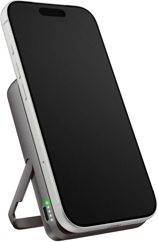 Witte smartphone op een donkergrijze magnetische powerbank met ingebouwde standaard in een schuine positie.