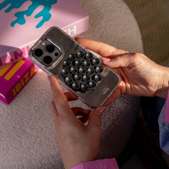 Iemand houdt een transparant telefoonhoesje met een zwarte zuignapsticker vast.
