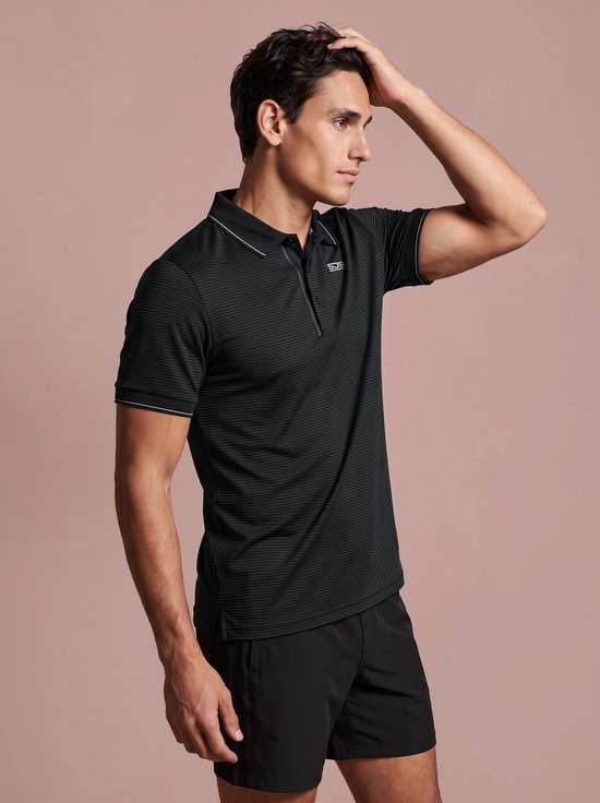Zijaanzicht van een model in een zwart-grijs gestreept Sjeng Sports poloshirt met witte kraagdetails.