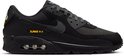 Zwarte Nike Air Max 90 sneaker met gele 'Air Max' details op de zijkant en hiel.