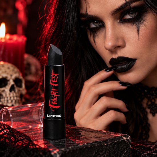 Zwarte Fright Fest lippenstift naast een vrouw met gotische make-up en zwarte lippen in een griezelige omgeving.
