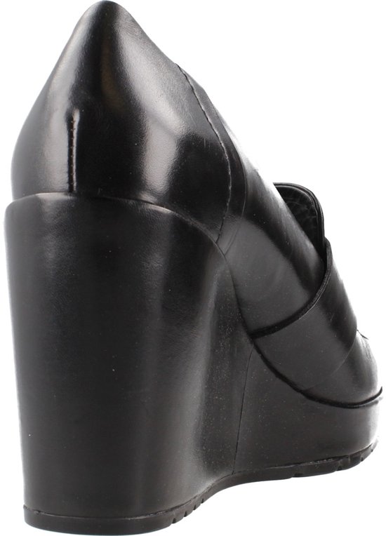 Achterkant van een zwarte leren wedge pump met puntige neus en hoge wigvormige hak.