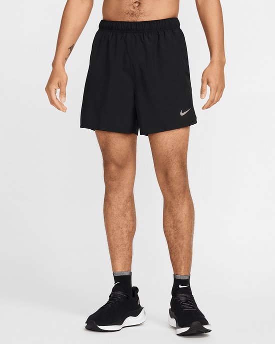 Man met zwarte Nike running shorts van 5 inch, met een reflecterende Nike swoosh.