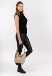 Model met beige suède buideltas met bruine hengsels en kwastje met logo.