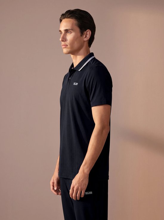 Man draagt een donkerblauw poloshirt met verticale ribbels, wit geborduurd logo op de borst.