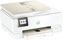Witte HP Envy Photo printer met beige details, lade open, touchscreen toont 'Copy', 'Scan' en 'Shortcuts'.