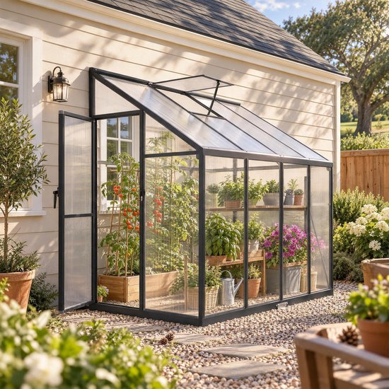 Zwarte muurkas met polycarbonaat panelen en tomatenplanten in een zonnige tuin.