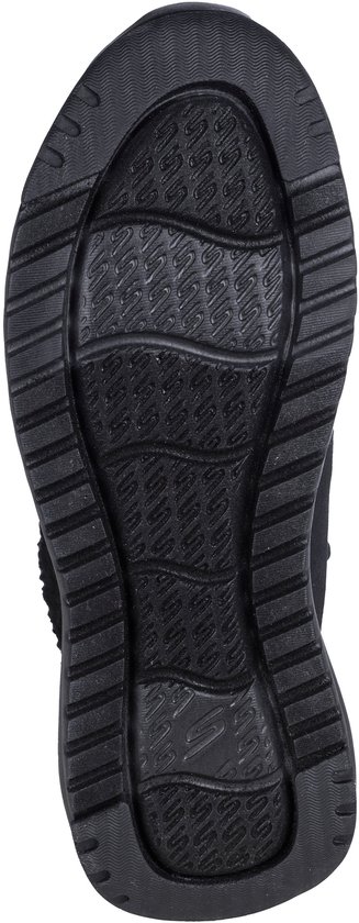 Zwarte, geribbelde rubberen buitenzool van een Skechers sneaker met een golfpatroon in het midden.