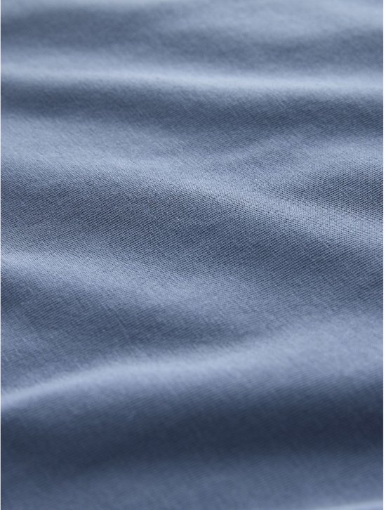Detailopname van blauwe jersey stof met fijne textuur.