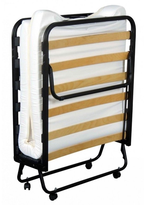 Een opgevouwen vouwbed met witte matras en houten lattenbodem, op wieltjes.