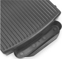 Detail van de geribbelde grillplaat van een zwarte Princess grill met opvangbakje.