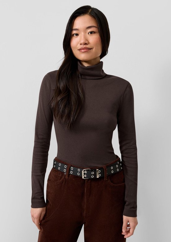 Model met lange mouwen, donkerbruine coltrui en bruine corduroy broek met riem.