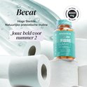 Flesje Novomins vezelgummies van 4000 mg op een stapel toiletrollen. Bevat hoge sterkte natuurlijke prebiotische inuline.
