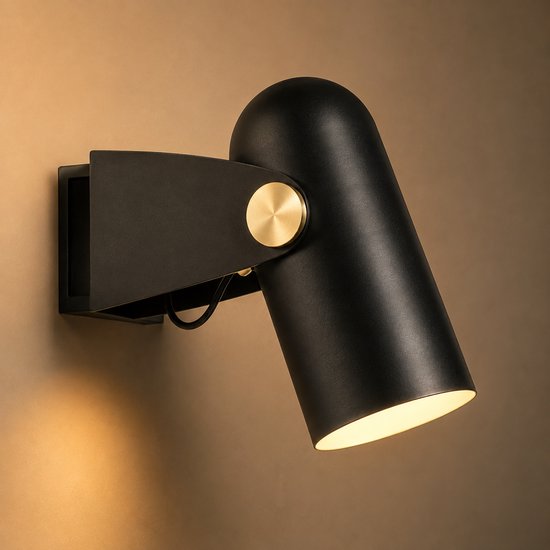 Applique murale noire et réglable avec un bouton doré et un abat-jour cylindrique incurvé.