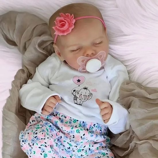 Slapende baby met roze bloem haarband, witte top met olifantprint, en een gebloemde broek, met een fopspeen in de mond.