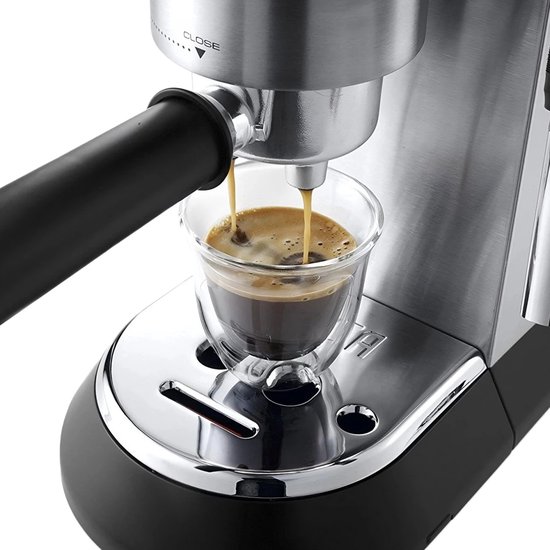 Zilverkleurige De'Longhi espressomachine met zwarte handgreep, die een espresso schenkt in een glazen kopje.