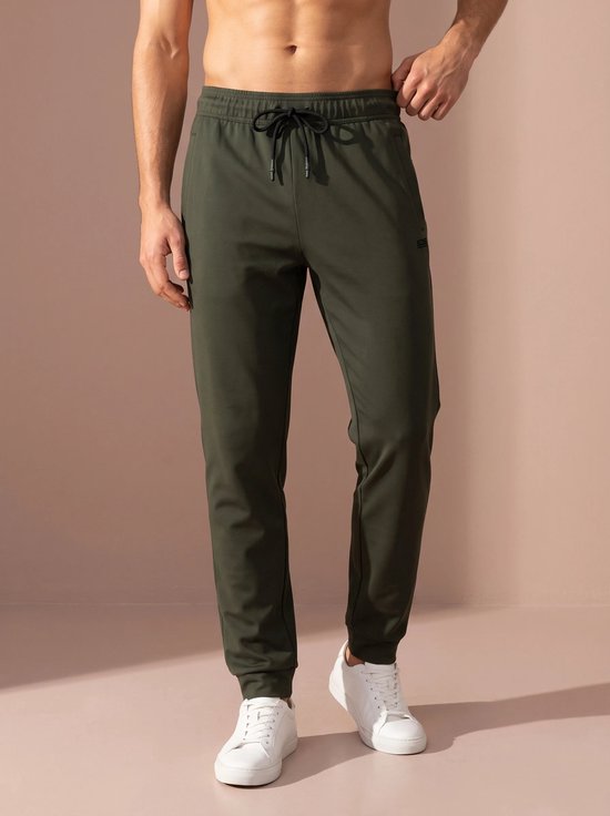 Olijfgroene joggingbroek met trekkoord, gedragen door een man.