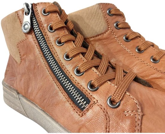 Close-up van cognackleurige leren sneakers met rits aan de zijkant.