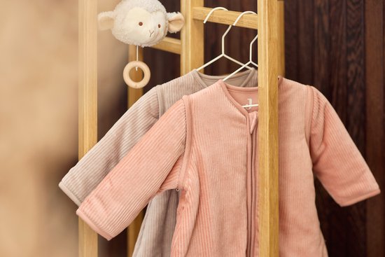 Babyslaapzakken aan een kledingrekje in de babykamer