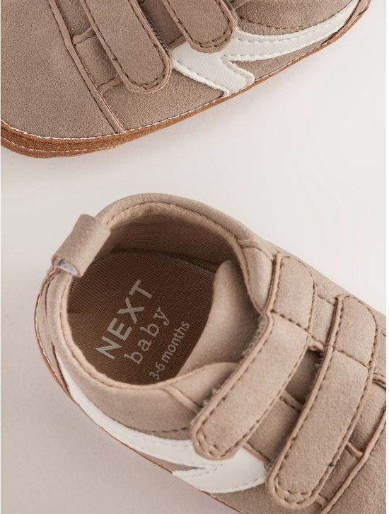 Bruine suède babysneakers met witte strepen. De binnenzool toont 'NEXT baby 3-6 months'.