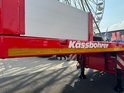 Rode aanhanger met witte tekst 'Kässbohrer' en gele reflecterende streep.