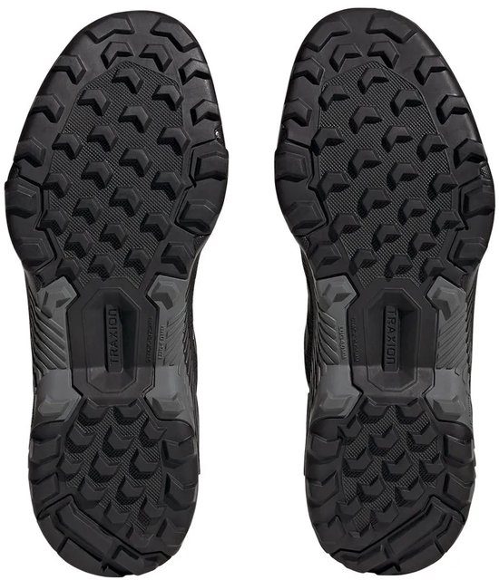 Zolen van zwarte dames wandelschoenen van adidas Terrex RAIN.RDY met grof profiel.