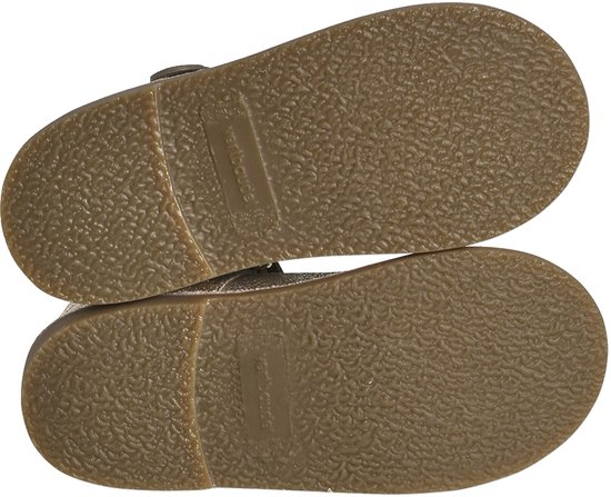 Onderkant van een paar gouden glitter Mary Jane schoenen, met bruine zolen.