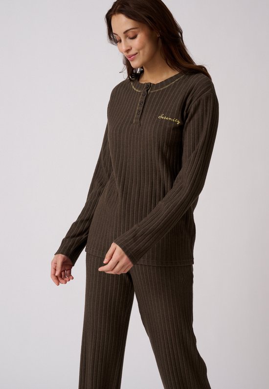 Model in bruine pyjamaset van ribtricot. De tekst "Serenity" staat geborduurd op de borst.