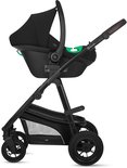 Zwarte kinderwagen met zwart autostoeltje en groene accenten.