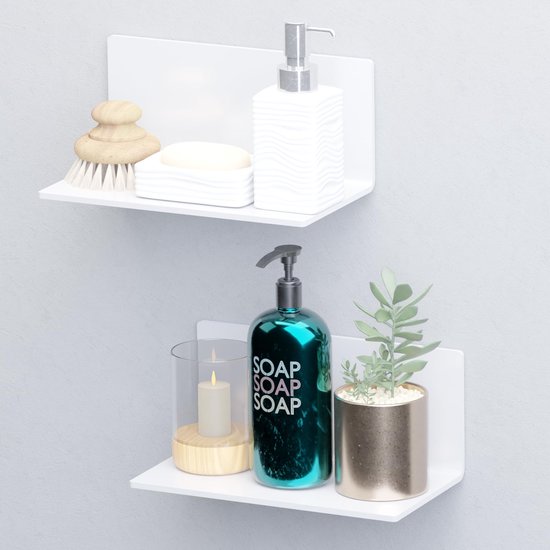 Twee witte zwevende planken met badkameraccessoires: zeepdispenser, zeep, borstel, kaars en plant.