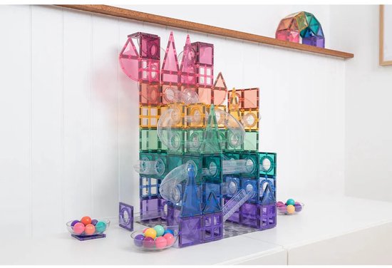 Een grote, kleurrijke constructie van pastel Connetix magnetische tegels met buizen, ballen en een tol.